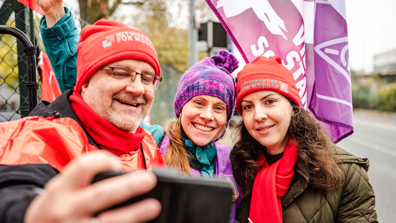 Drei Beschäftigte machen ein Selfie beim Warnstreik in der Metall-Tarifrunde